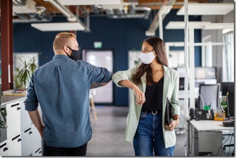 Two business colleagues greeting with elbow in office. Business people bump elbows in office for greeting during covid-19 pandemic.