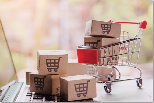 Shopping online concept - Parcel or Paper cartons with a shopping cart logo in a trolley on a laptop keyboard. Shopping service on The online web. offers home delivery.
