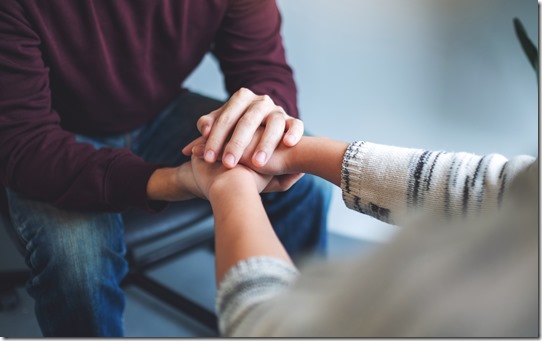 A man and a woman holding each other hands for comfort and love