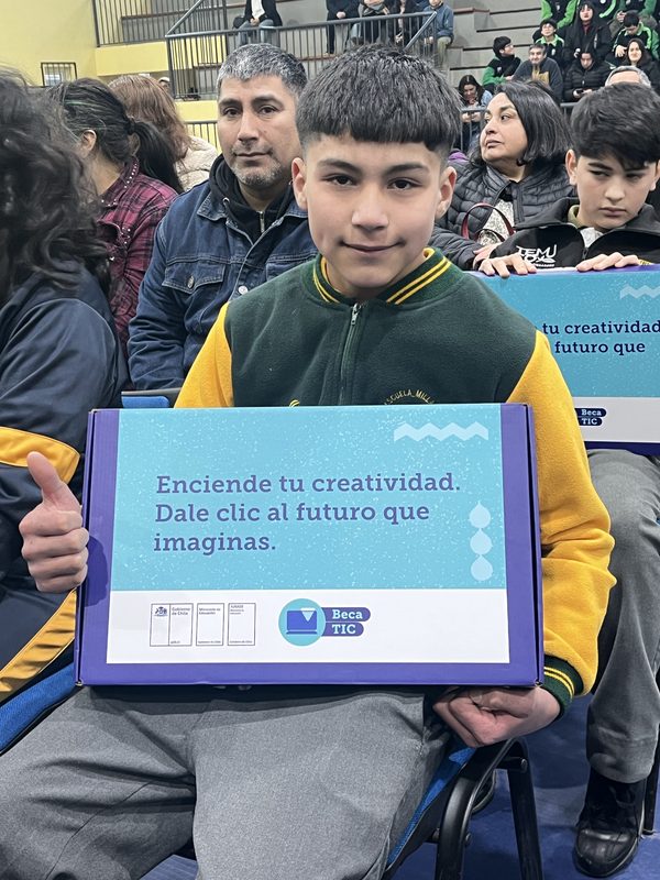 Estudiante recibiendo su computador de la Beca TIC 2026 en ceremonia oficial
