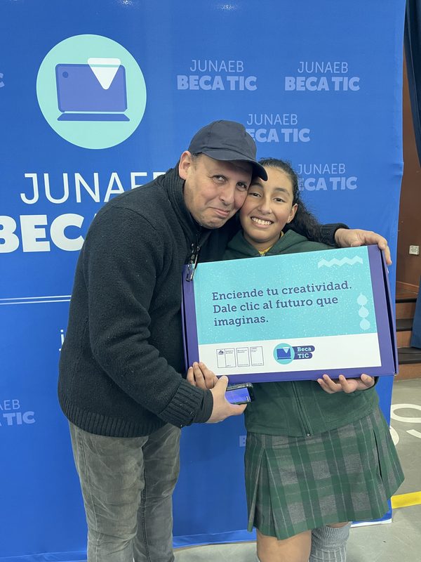 Estudiante recibiendo su computador de la Beca TIC 2026 en ceremonia oficial