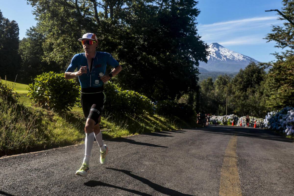 Triatletas compitiendo en el Ironman 70.3 de Pucón con el volcán Villarrica al fondo