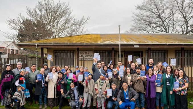 Personal del Hospital de Traiguén y representantes de la comunidad mapuche revisando documentos de salud intercultural.