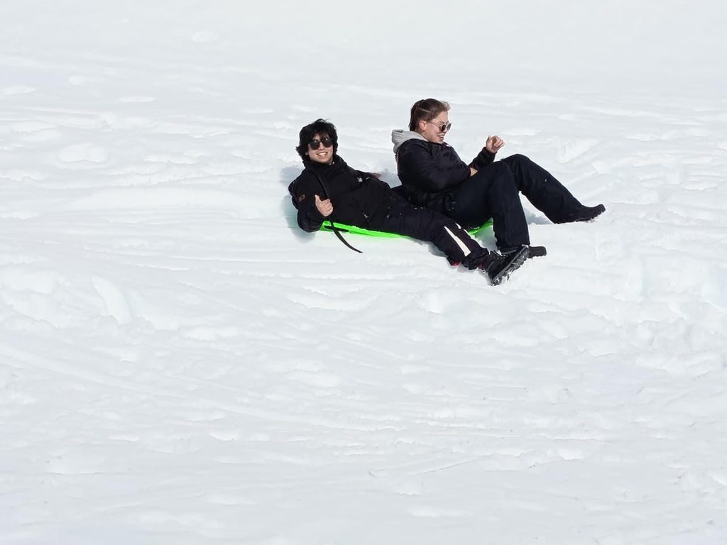 Estudiantes de la Región de La Araucanía disfrutando de actividades recreativas en la nieve cerca del volcán Llaima durante una jornada de ASEM Chile.