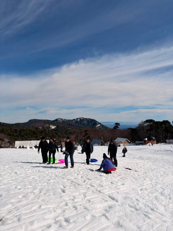 Estudiantes de la Región de La Araucanía disfrutando de actividades recreativas en la nieve cerca del volcán Llaima durante una jornada de ASEM Chile.