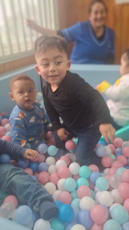 Niños y niñas participando en actividades recreativas junto a sus familias en el Jardín Infantil Los Copihues del Volcán