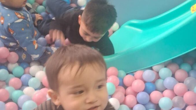 Niños y niñas participando en actividades recreativas junto a sus familias en el Jardín Infantil Los Copihues del Volcán