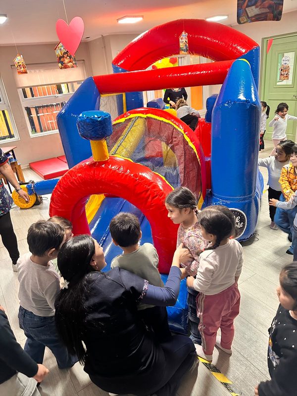 Niños y niñas participando en actividades recreativas junto a sus familias en el Jardín Infantil Los Copihues del Volcán