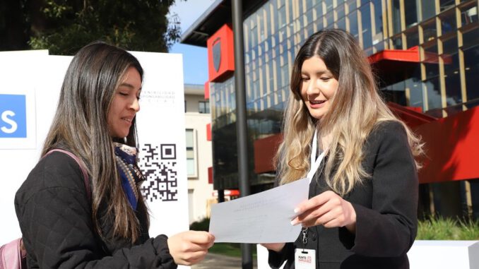 Personas visitando stands de la feria laboral Punto Empleo en la Universidad Autónoma de Chile