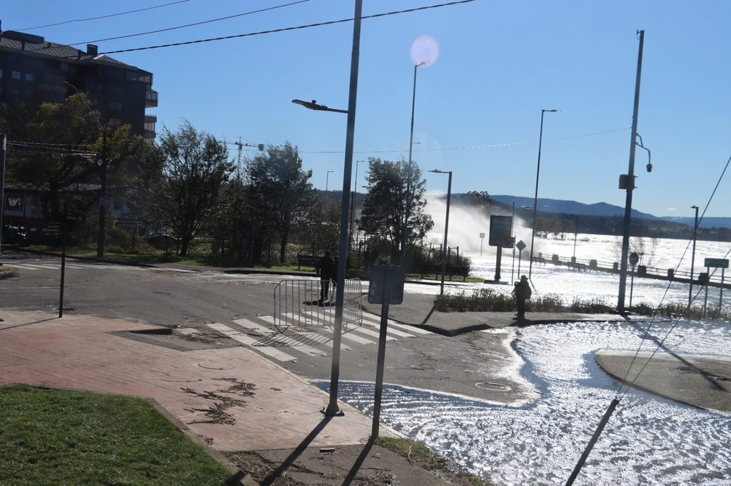 Trabajadores municipales retirando ramas y residuos en la Costanera de Villarrica tras el fuerte oleaje
