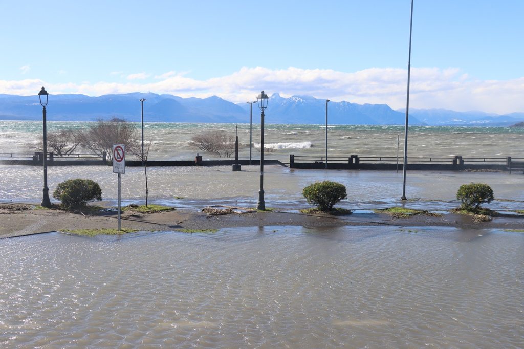 Trabajadores municipales retirando ramas y residuos en la Costanera de Villarrica tras el fuerte oleaje