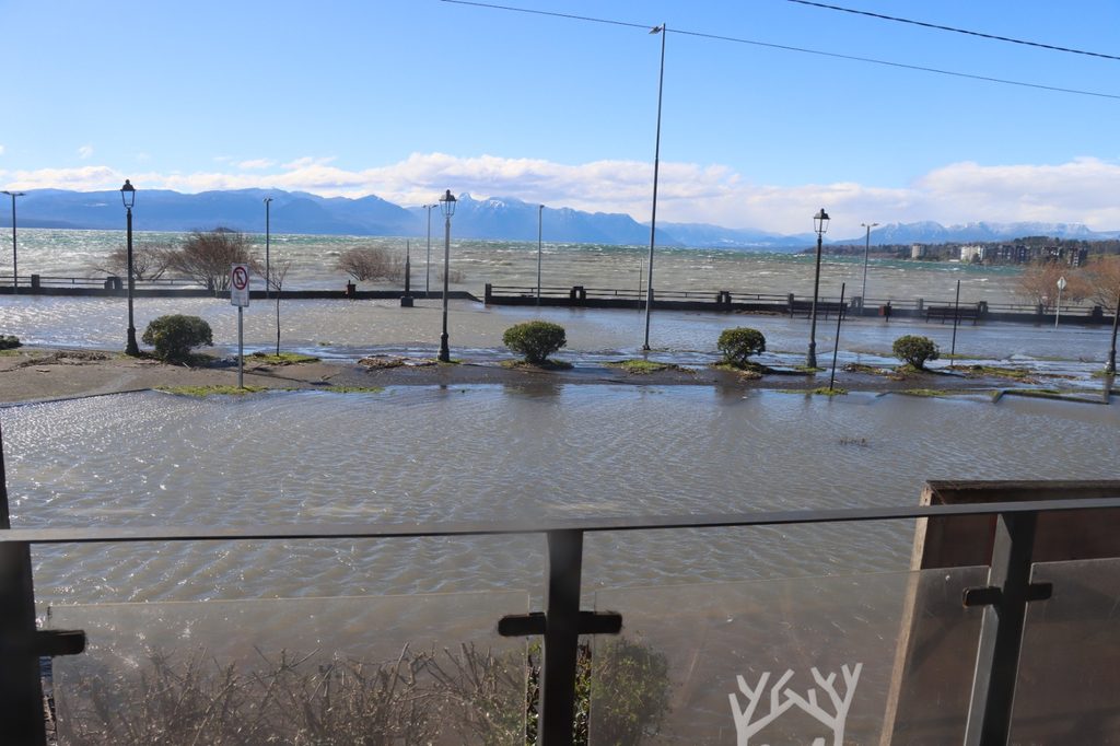 Trabajadores municipales retirando ramas y residuos en la Costanera de Villarrica tras el fuerte oleaje