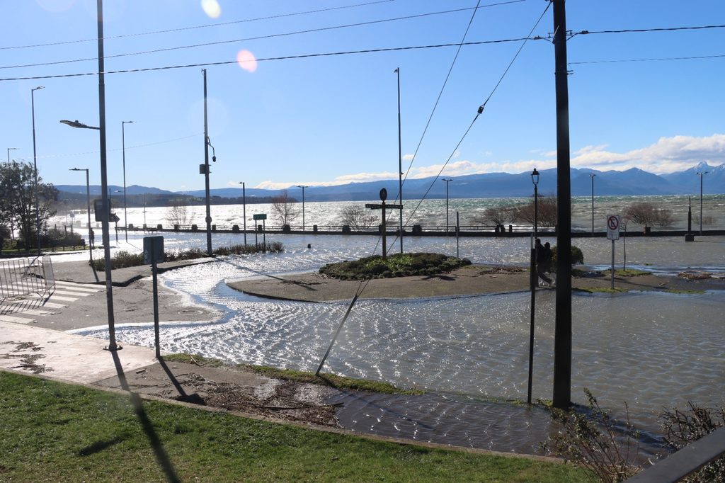 Trabajadores municipales retirando ramas y residuos en la Costanera de Villarrica tras el fuerte oleaje