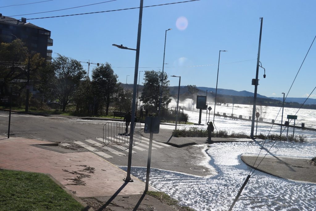 Trabajadores municipales retirando ramas y residuos en la Costanera de Villarrica tras el fuerte oleaje