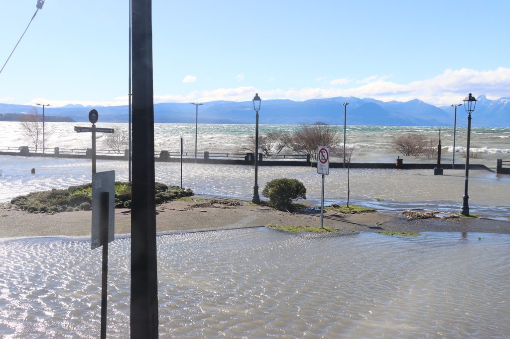 Trabajadores municipales retirando ramas y residuos en la Costanera de Villarrica tras el fuerte oleaje