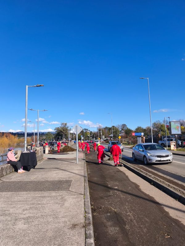 Trabajadores municipales retirando ramas y residuos en la Costanera de Villarrica tras el fuerte oleaje
