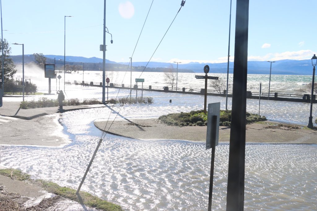 Trabajadores municipales retirando ramas y residuos en la Costanera de Villarrica tras el fuerte oleaje