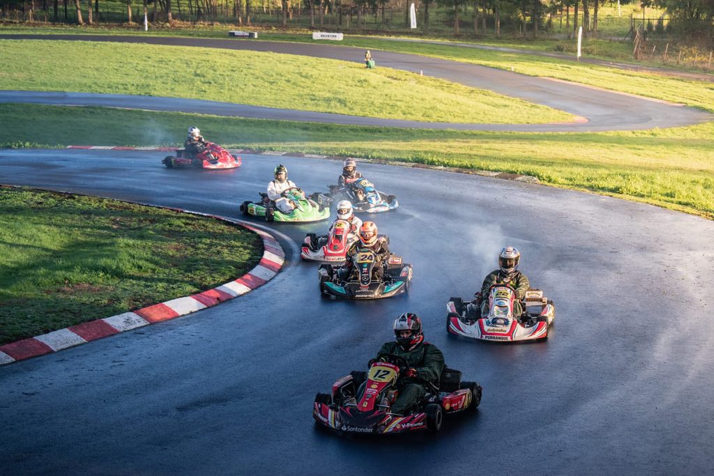 Pilotos compitiendo bajo una intensa lluvia en el Campeonato Regional de Karting en Temuco