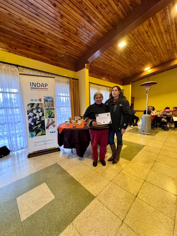 Mujeres rurales de Victoria participando en taller de conservas y encurtidos junto a sus productos elaborados
