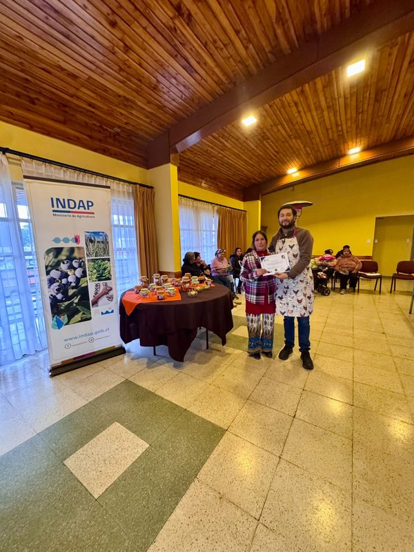 Mujeres rurales de Victoria participando en taller de conservas y encurtidos junto a sus productos elaborados