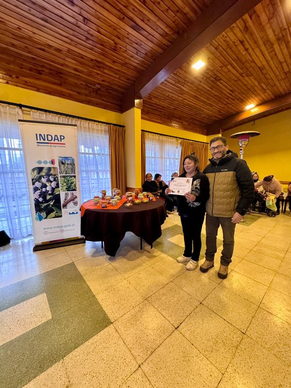 Mujeres rurales de Victoria participando en taller de conservas y encurtidos junto a sus productos elaborados
