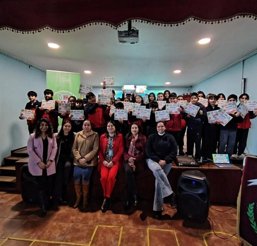 Niños participando en actividades creativas de pintura y escritura en biblioteca municipal