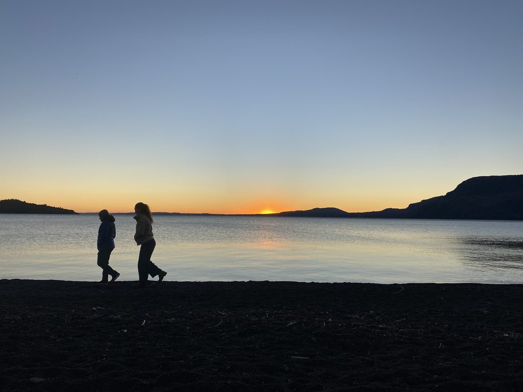 Paisaje del Lago Villarrica bajo cielos despejados con autoridades locales celebrando el plan de descontaminación