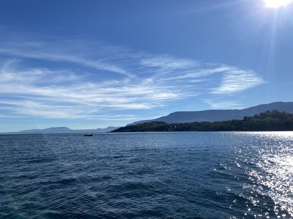 Paisaje del Lago Villarrica bajo cielos despejados con autoridades locales celebrando el plan de descontaminación