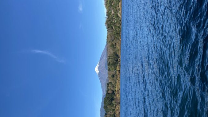 Paisaje del Lago Villarrica bajo cielos despejados con autoridades locales celebrando el plan de descontaminación