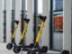 Usuario utilizando un scooter eléctrico compartido en una calle urbana de Santiago