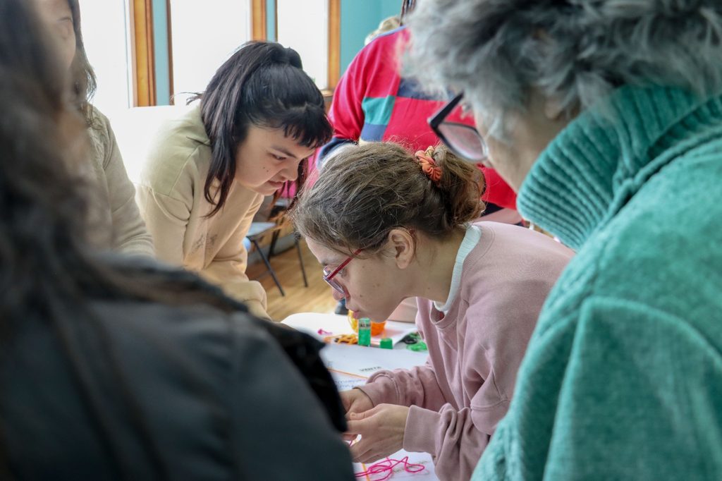 Grupo de personas con discapacidad y cuidadores participando en un taller creativo de manualidades en Villarrica