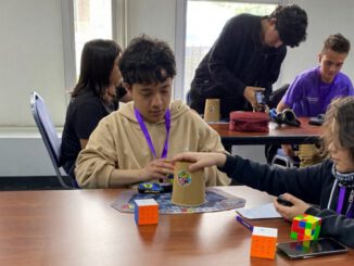 Competidor resolviendo un cubo Rubik en el evento UFRO al Cubo en el Gimnasio Olímpico de Temuco.