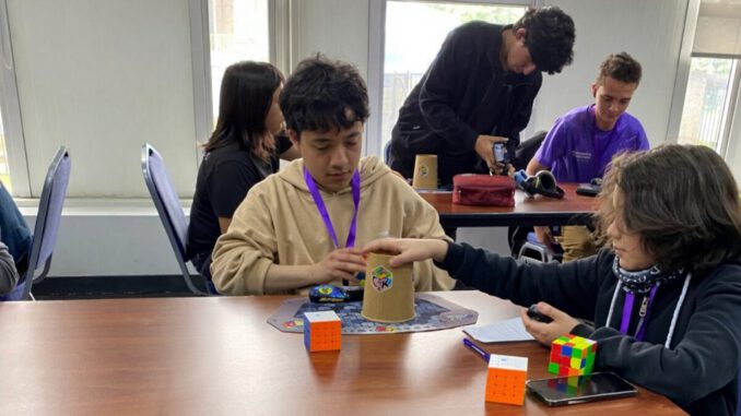 Competidor resolviendo un cubo Rubik en el evento UFRO al Cubo en el Gimnasio Olímpico de Temuco.