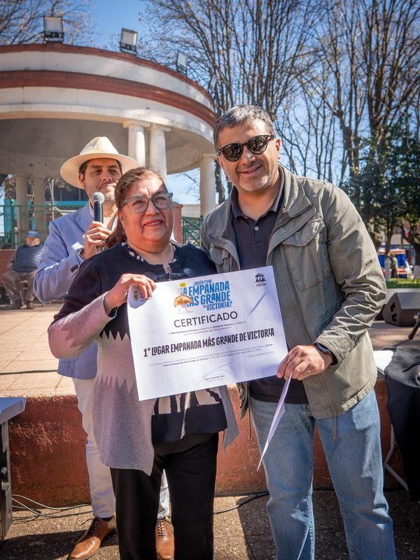 Berta Arévalo Vega posando orgullosa junto a su empanada de 57 centímetros ganadora en Victoria