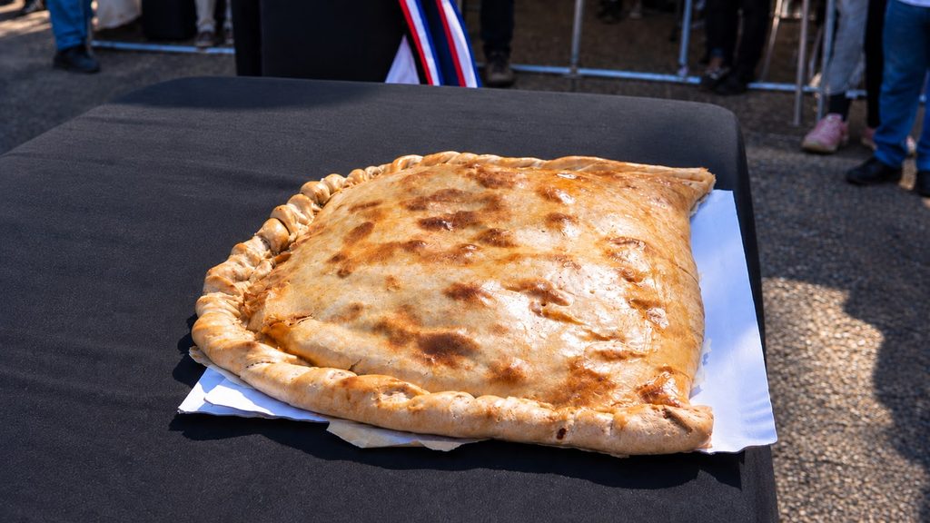 Berta Arévalo Vega posando orgullosa junto a su empanada de 57 centímetros ganadora en Victoria