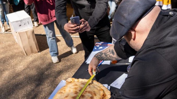 Berta Arévalo Vega posando orgullosa junto a su empanada de 57 centímetros ganadora en Victoria