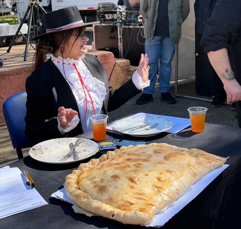 Berta Arévalo Vega posando orgullosa junto a su empanada de 57 centímetros ganadora en Victoria