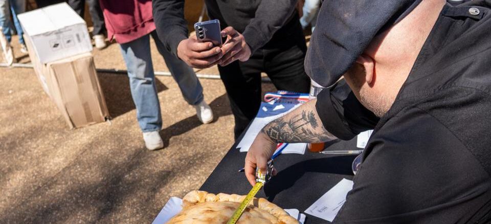 Berta Arévalo Vega posando orgullosa junto a su empanada de 57 centímetros ganadora en Victoria