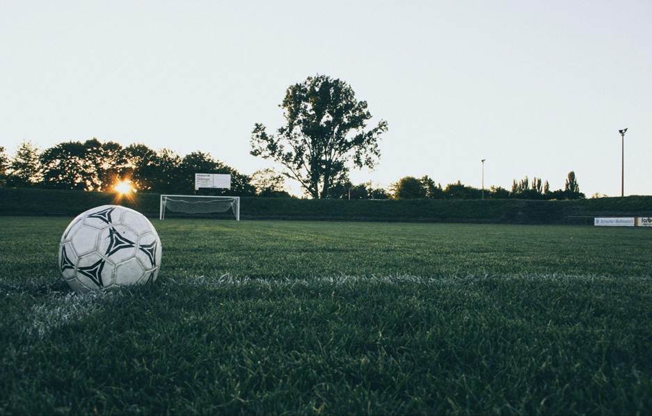 Balón de fútbol en un campo al amanecer