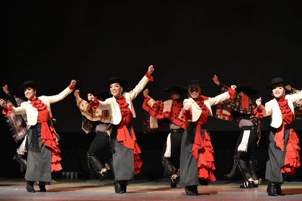 Bailarines del Ballet Folklórico Magia Chilena realizando una coreografía tradicional en el escenario