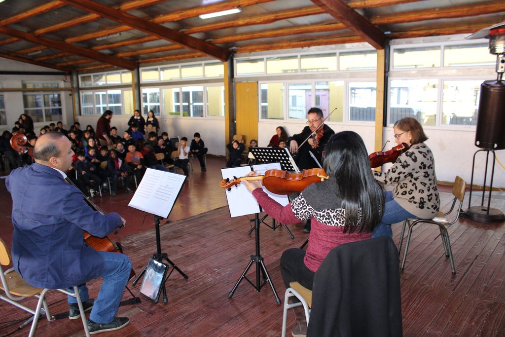 Estudiantes de la Escuela Standard interactuando con músicos de la Orquesta Filarmónica de Temuco en una jornada educativa.