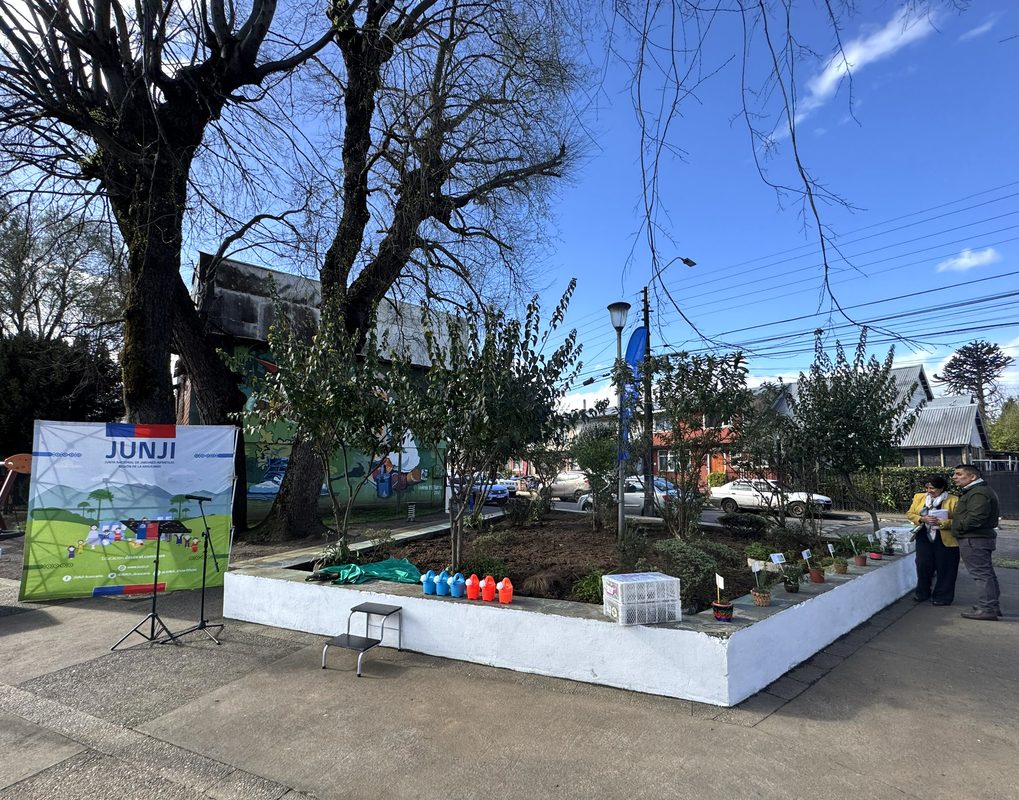 Niños y vecinos participando en la reactivación del huerto medicinal del Jardín Infantil Capullito en Temuco
