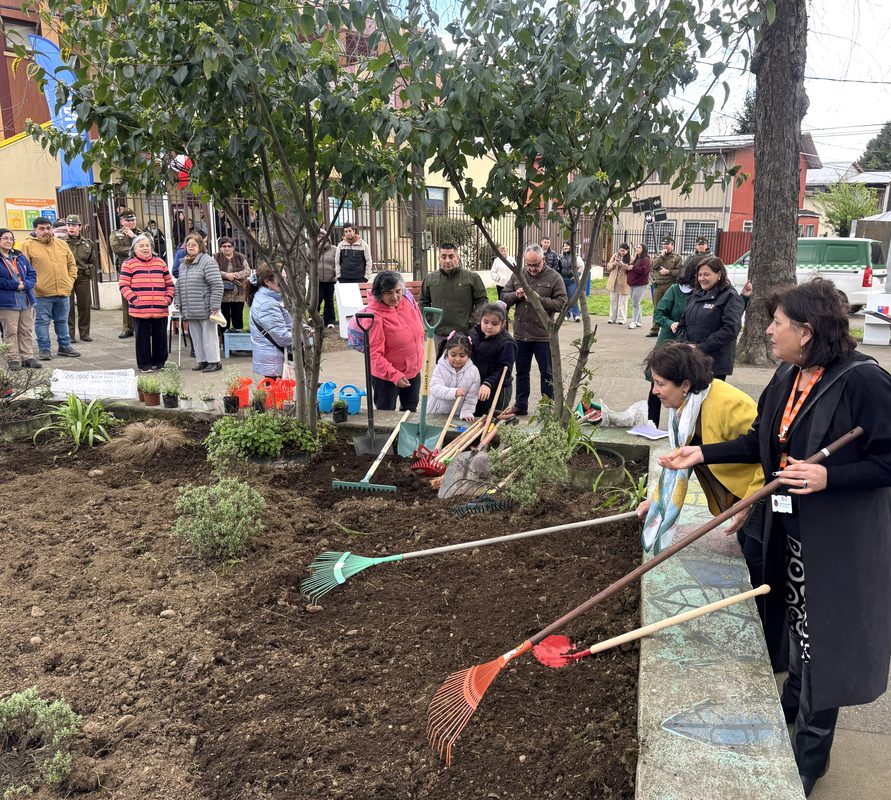 Niños y vecinos participando en la reactivación del huerto medicinal del Jardín Infantil Capullito en Temuco