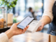 Persona utilizando pago digital con smartphone en un comercio chileno