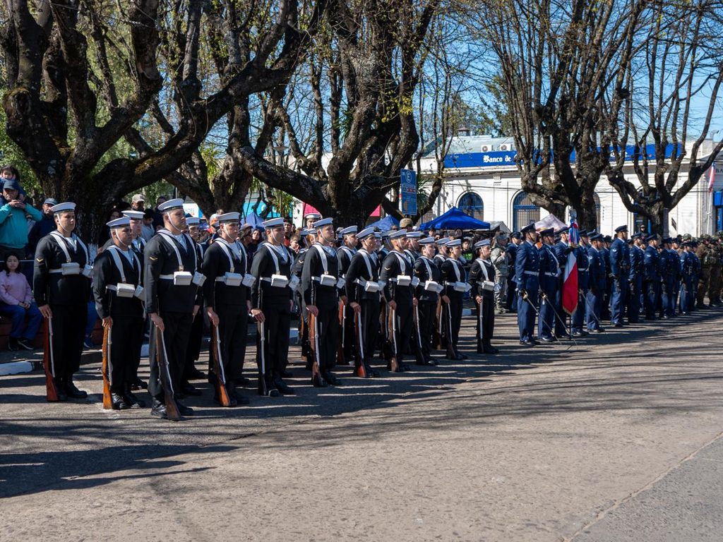 Perrito callejero jugando con la guaripola durante el desfile de la Parada Militar en Victoria