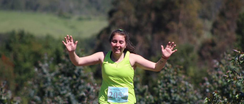 Liceth Montecino celebrando en el podio tras una competencia de trail running en la región de La Araucanía