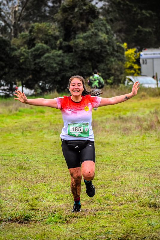 Liceth Montecino celebrando en el podio tras una competencia de trail running en la región de La Araucanía