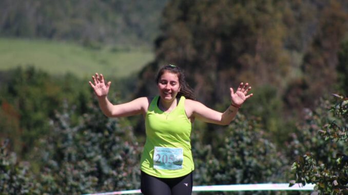Liceth Montecino celebrando en el podio tras una competencia de trail running en la región de La Araucanía