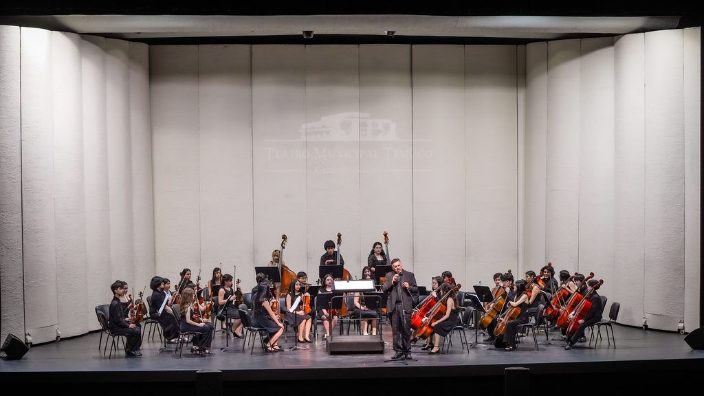 Jóvenes músicos de la Orquesta Infantil Juvenil de Temuco tocando en el escenario durante su gala anual