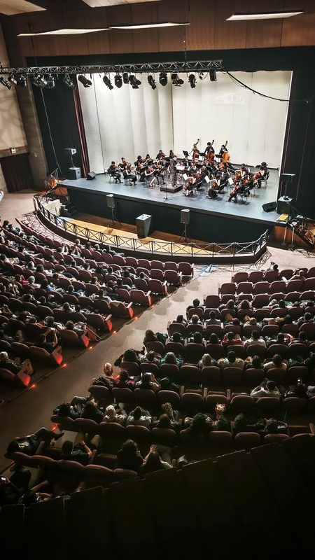 Jóvenes músicos de la Orquesta Infantil Juvenil de Temuco tocando en el escenario durante su gala anual